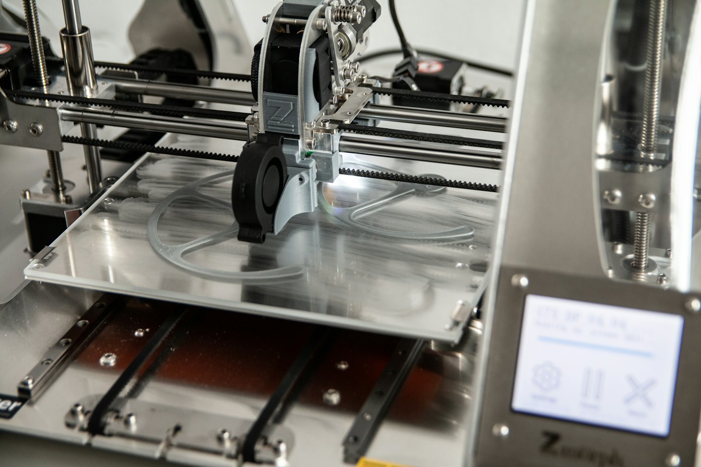 3D printer creating a part on its build plate.